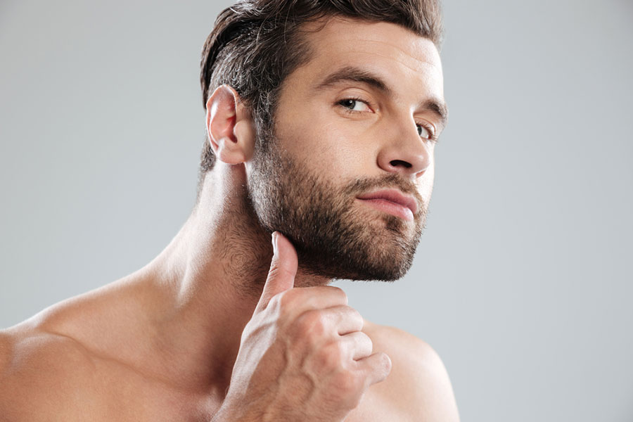 A handsome man examines his beard