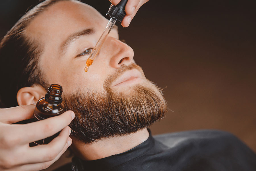 A man moisturizes beard with oil